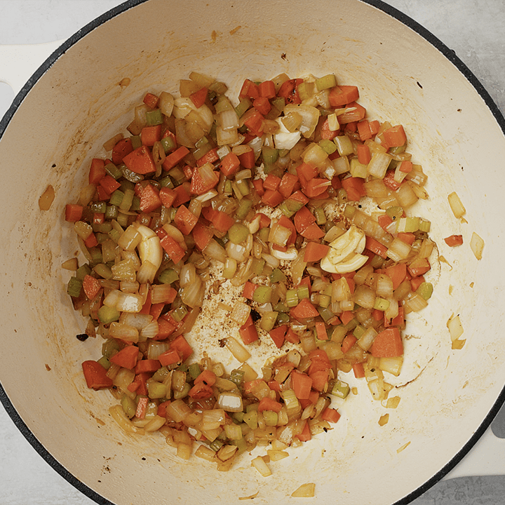 Sauteed mirepoix (onion, celery, and carrot) in a dutch oven with garlic.