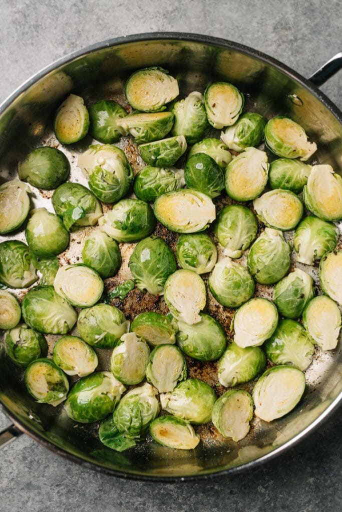 Trimmed and halved brussels sprouts in a large skillet tossed in bacon fat.