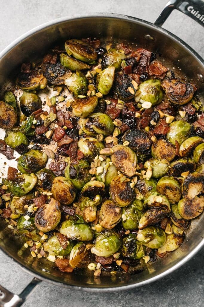 Christmas brussels sprouts with bacon, cranberries, and pistachios in a large skillet.