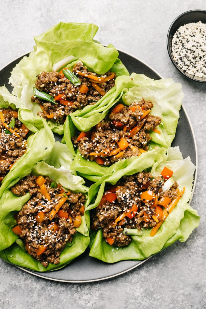 A black platter of asian ground beef lettuce wraps.