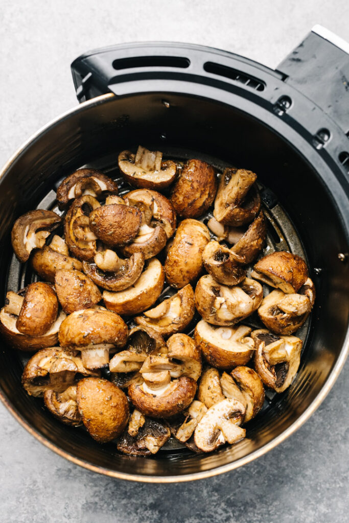 Air fryer mushrooms halfway through cooking.