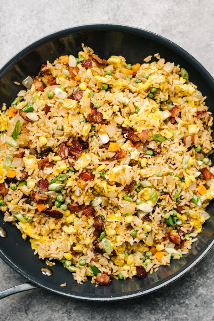 Breakfast fried rice with bacon in a skillet.