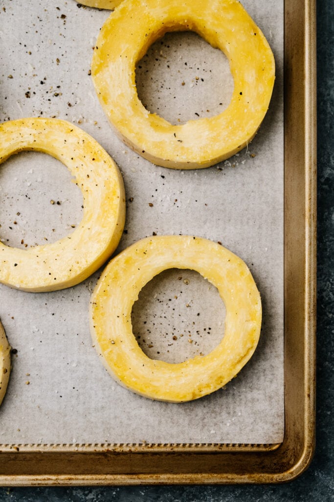 Spaghetti squash coins on a parchment lined baking sheet.