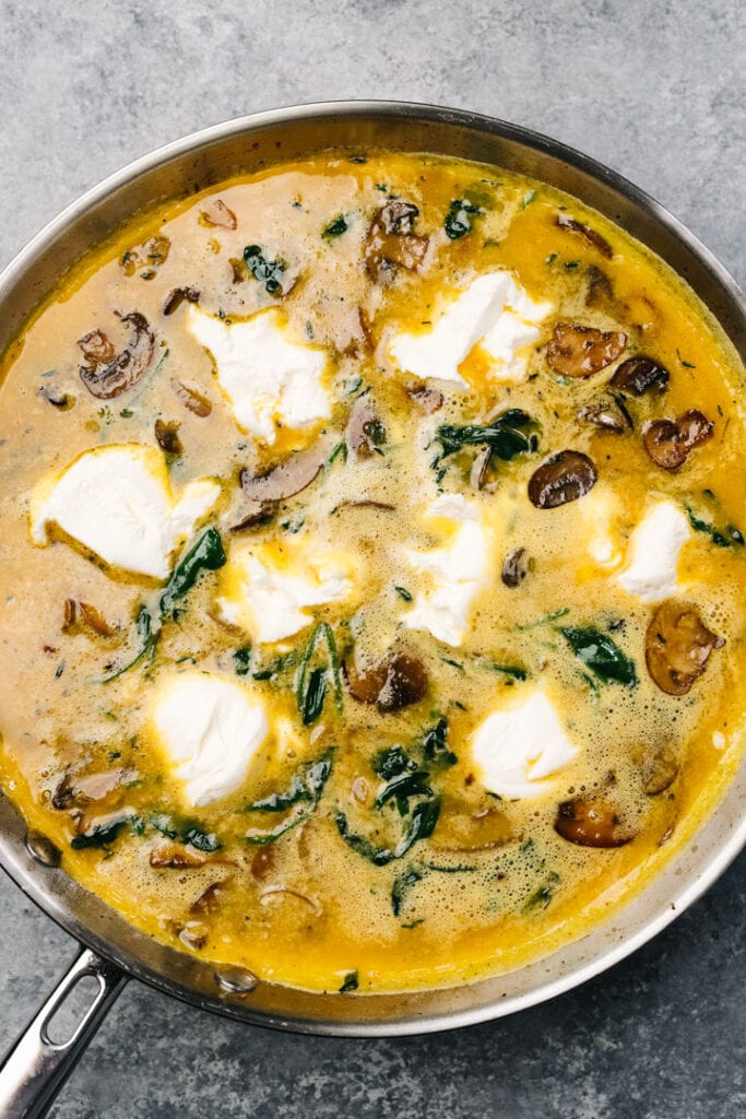 A mushroom frittata in a skillet just before being transferred to the oven.