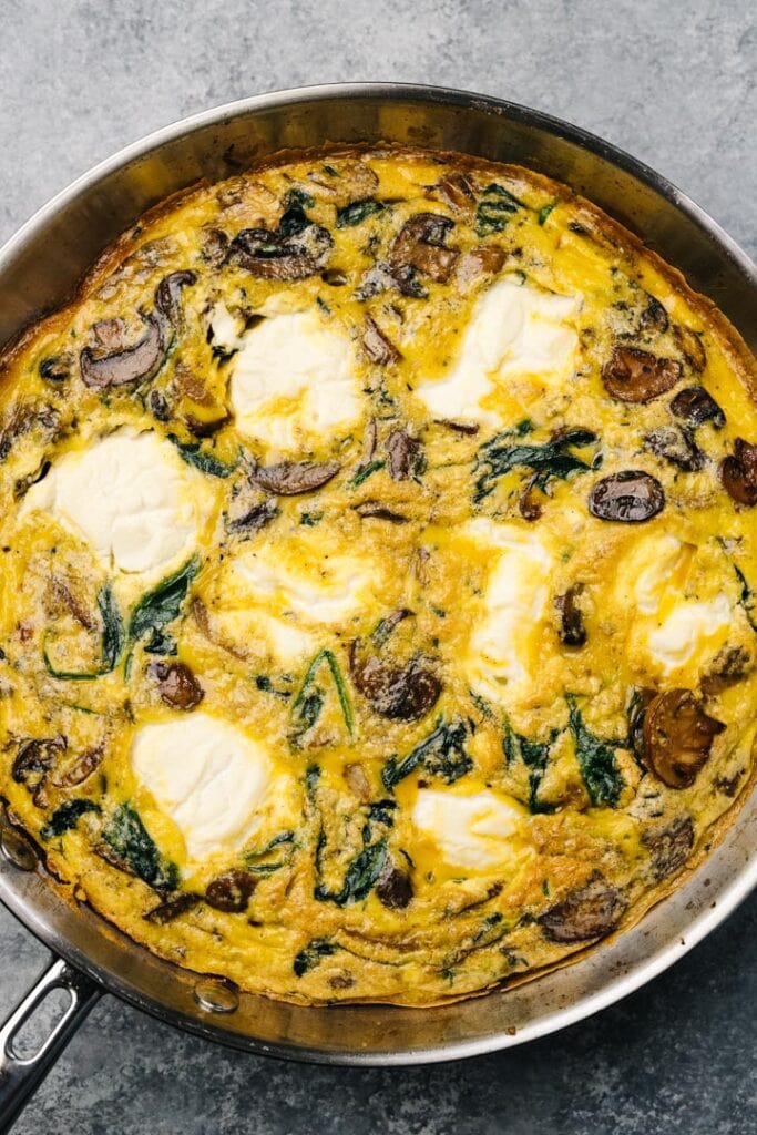 A baked mushroom frittata in a skillet, fresh from the oven.