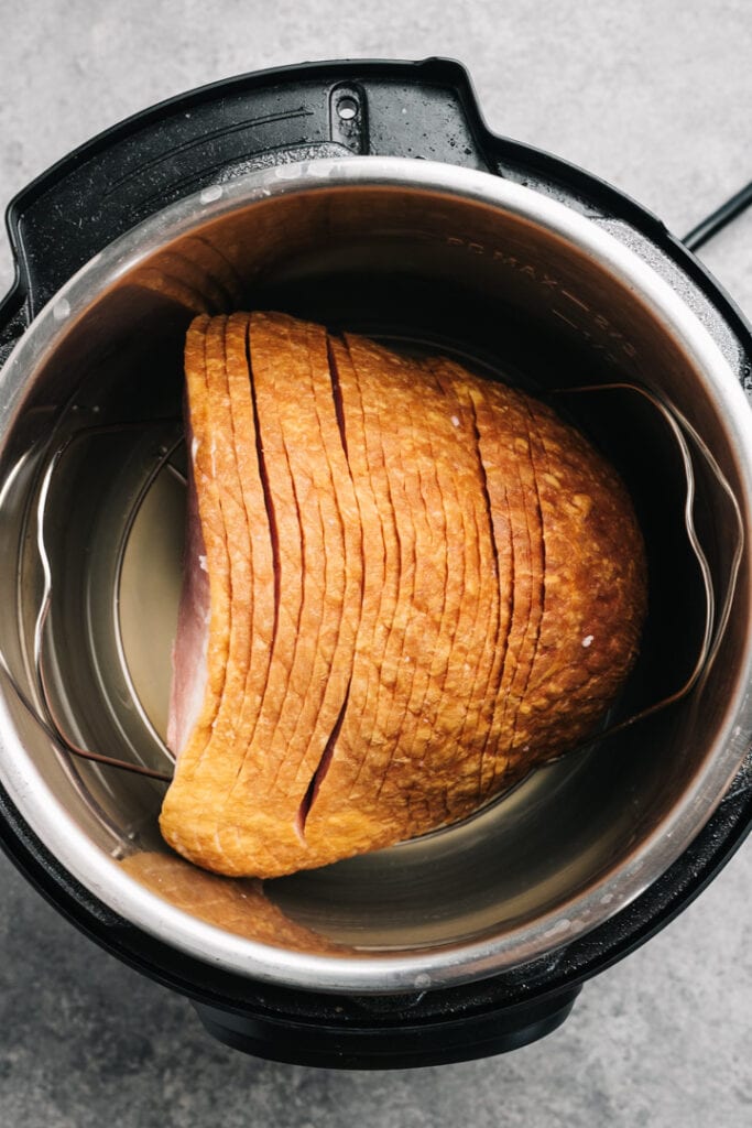 A pre-sliced spiral ham on a trivet, nestled into an Instant Pot.