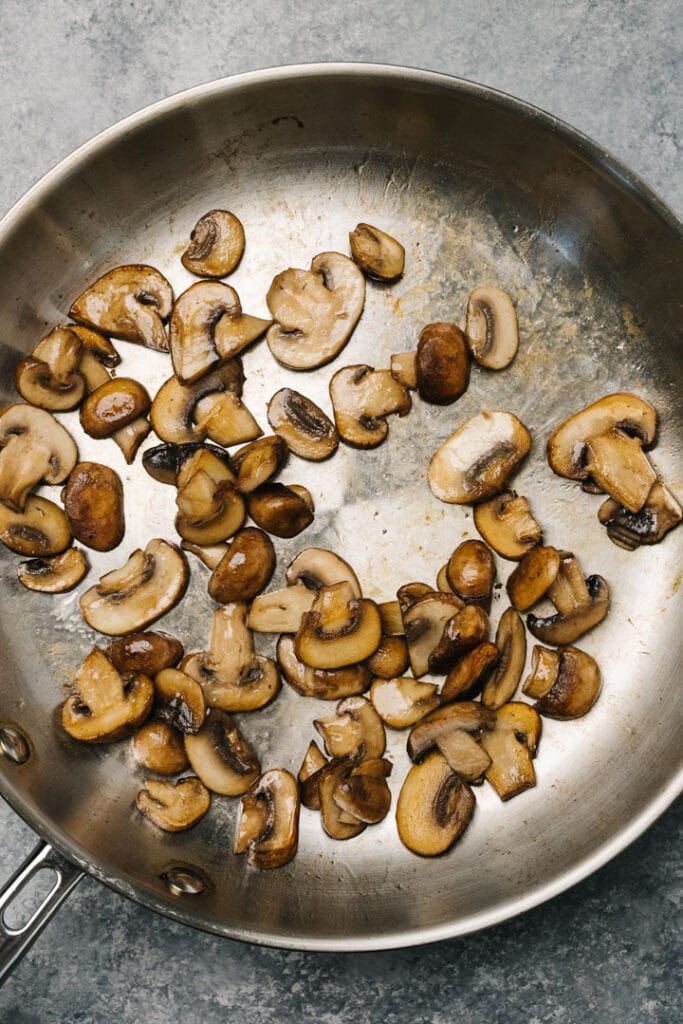 Sautéed crimini mushrooms in a skillet.