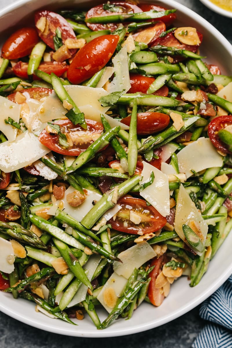 Asparagus salad in a large white serving bowl.