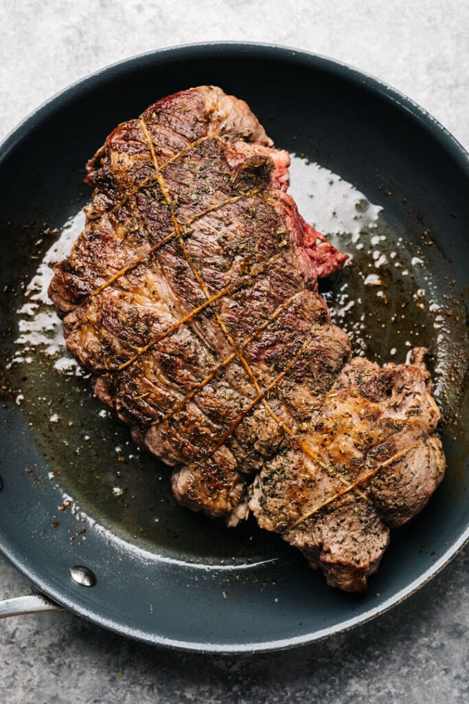 Seared chuck roast in a large skillet.