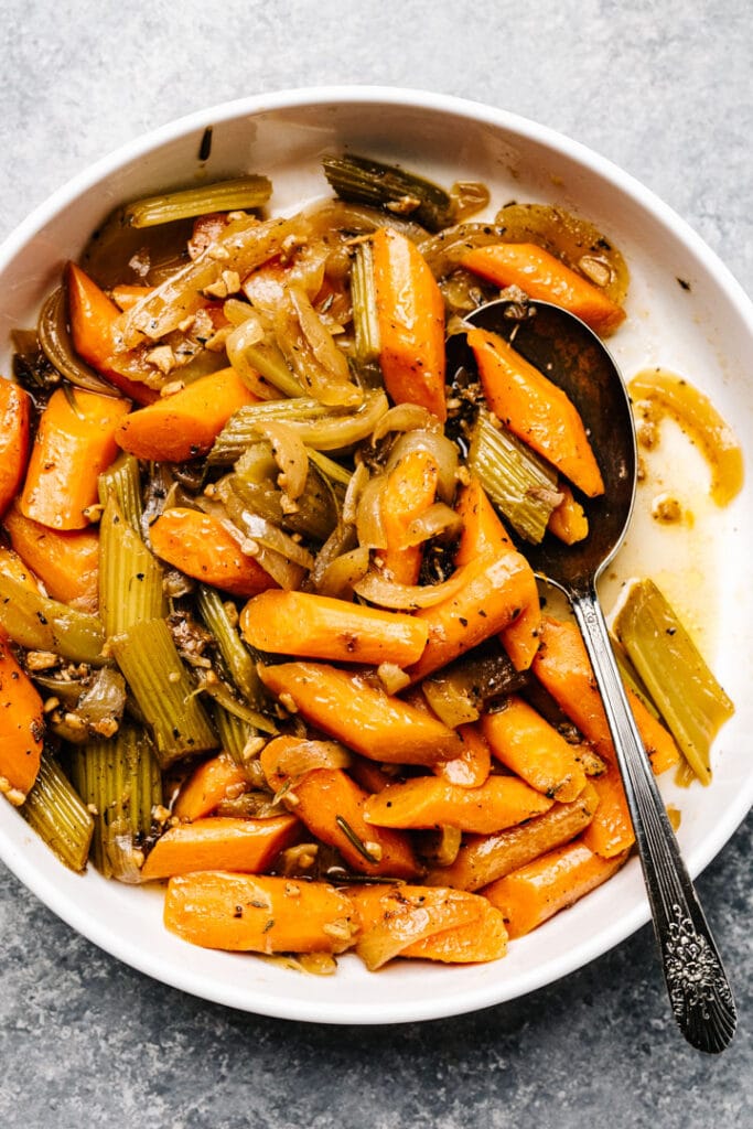 Strained carrots and celery from a pot roast in a white serving bowl.
