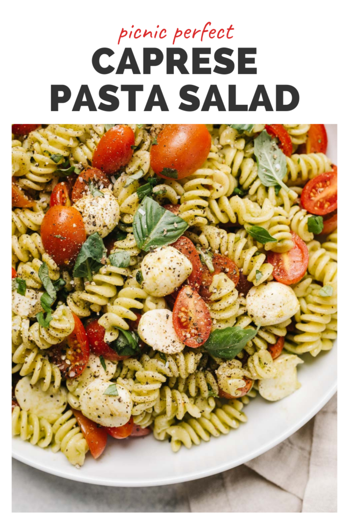 Bowl of caprese pasta salad with a banner on top that reads potluck perfect caprese pasta salad.