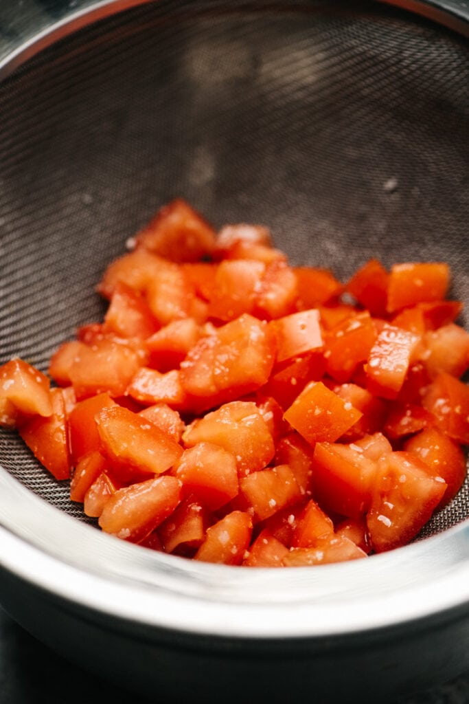 Chopped tomatoes in a strainer. 