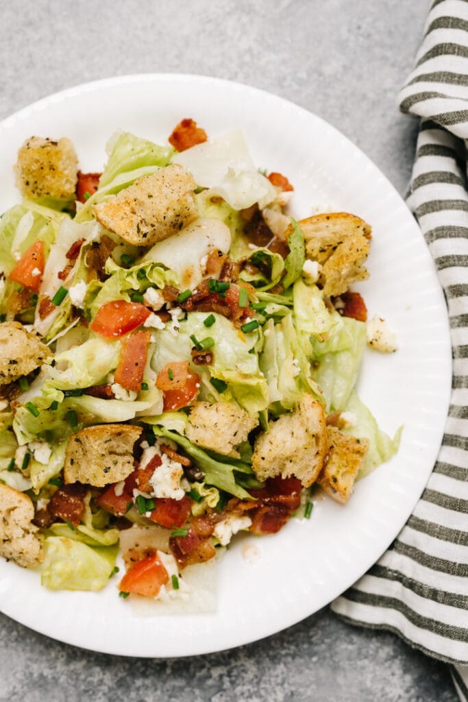 Chopped salad with croutons on a white plate. 