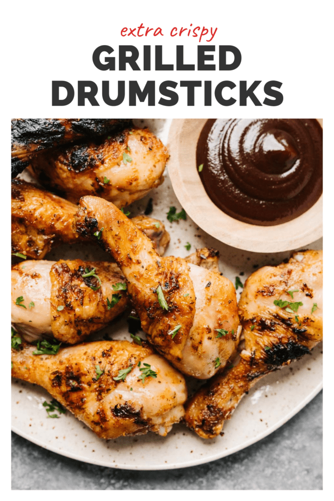 Grilled chicken drumsticks on a plate with dipping sauce, top banner reads extra crispy grilled drumsticks.