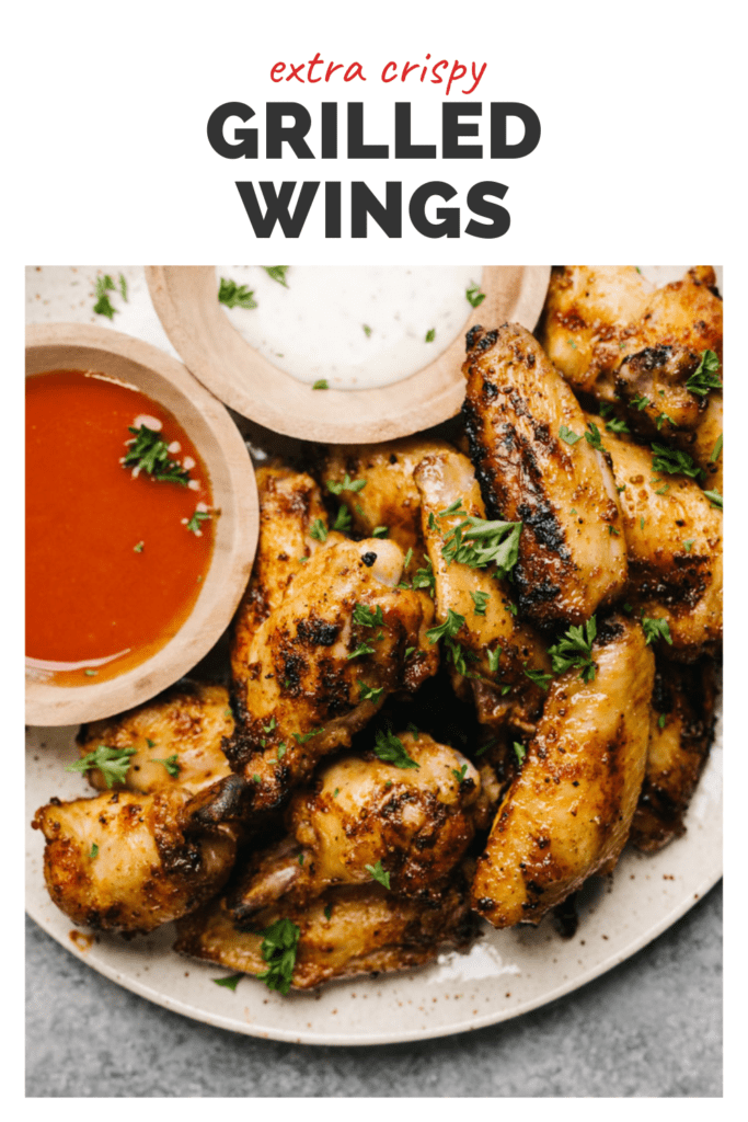 Grilled chicken wings with dipping sauces, with a white banner up top reading extra crispy grilled wings.