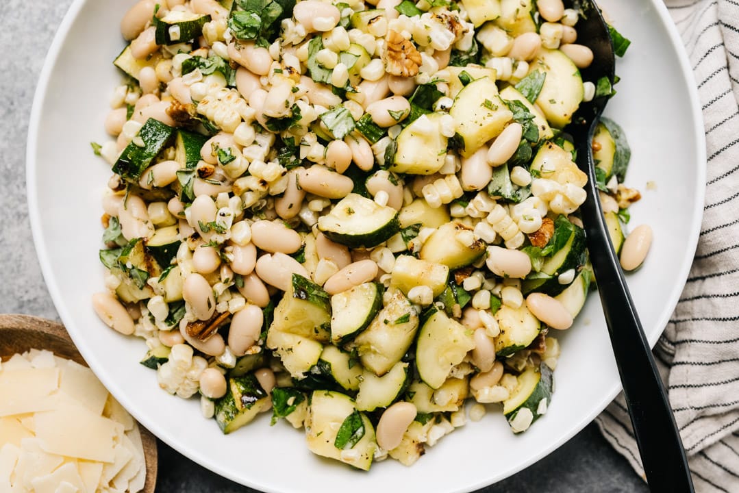 A white bowl with grilled zucchini salad. 