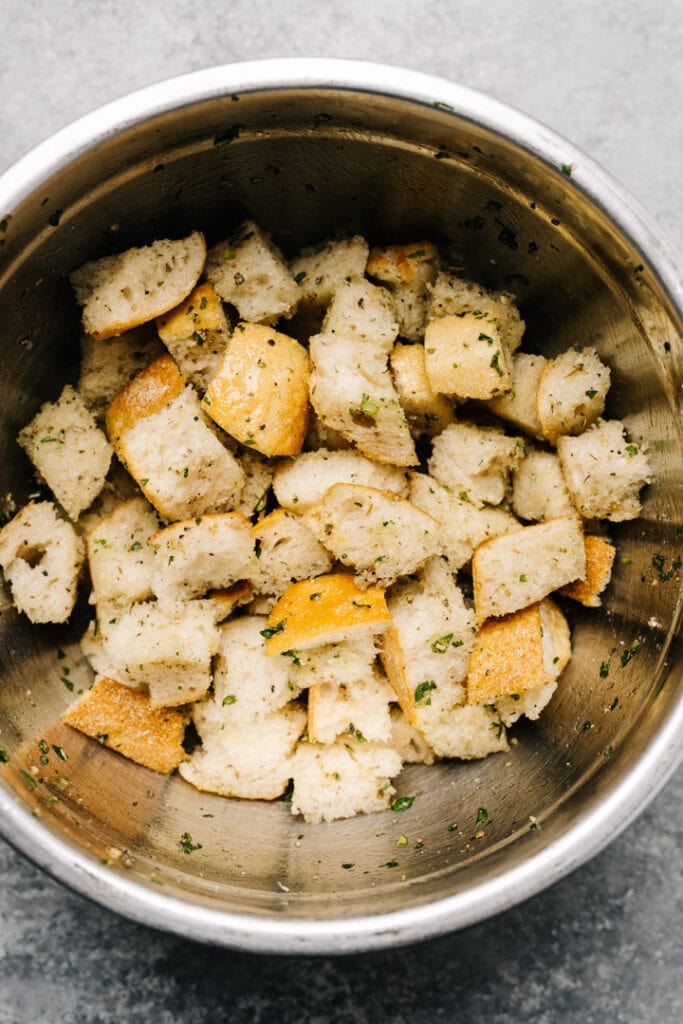Herbed and buttered bread cubes in a bowl. 