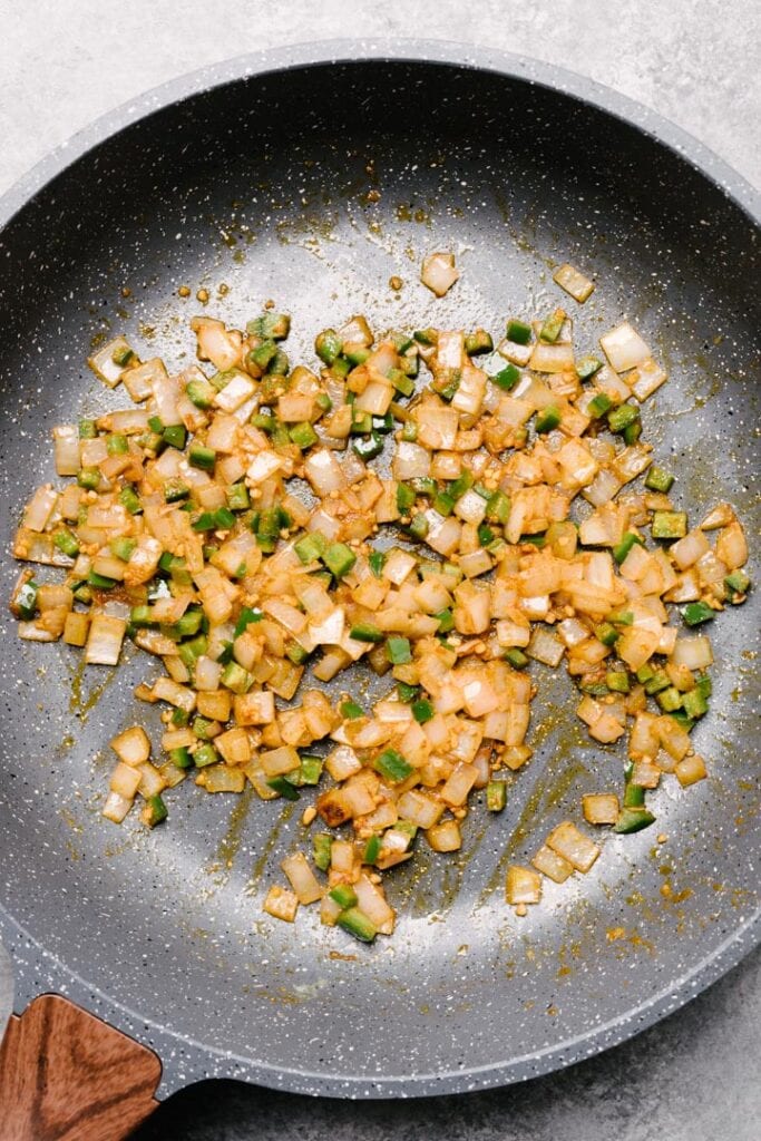 Sautéed diced onions and minced jalapenos seasoned with cumin and paprika in a nonstick skillet.