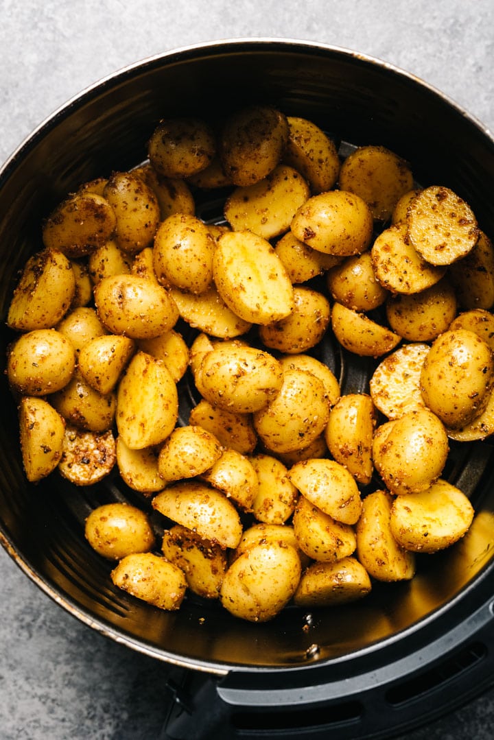 Seasoned raw potatoes in an air fryer. 