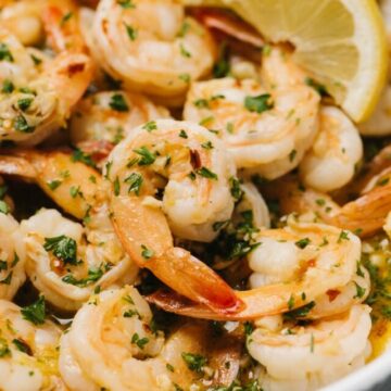 A close up of a bowl of fully cooked lemon garlic butter shrimp.
