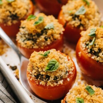 Side view, healthy stuffed tomatoes with quinoa in a casserole dish.
