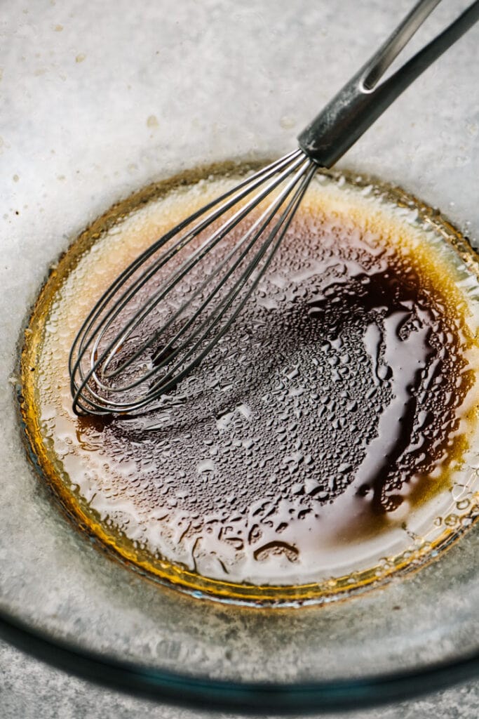 Balsamic vinegar dressing getting whisked in a bowl. 