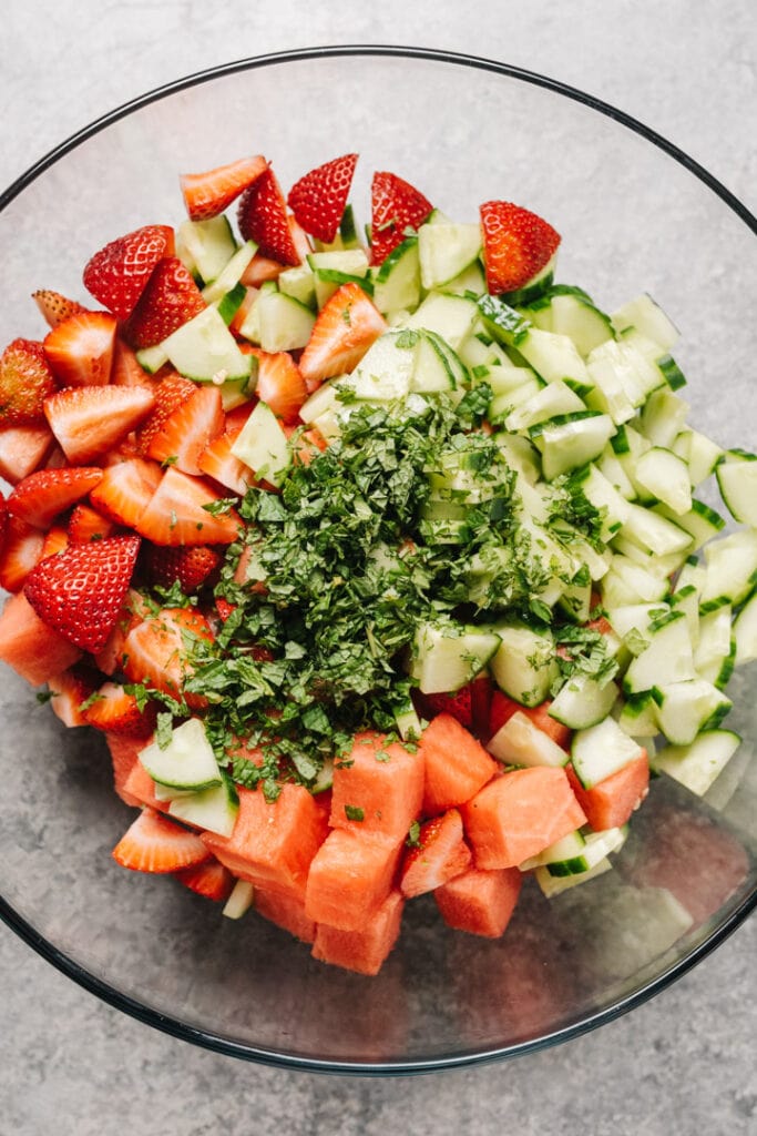 Watermelon salad ingredients in a bowl, unmixed. 