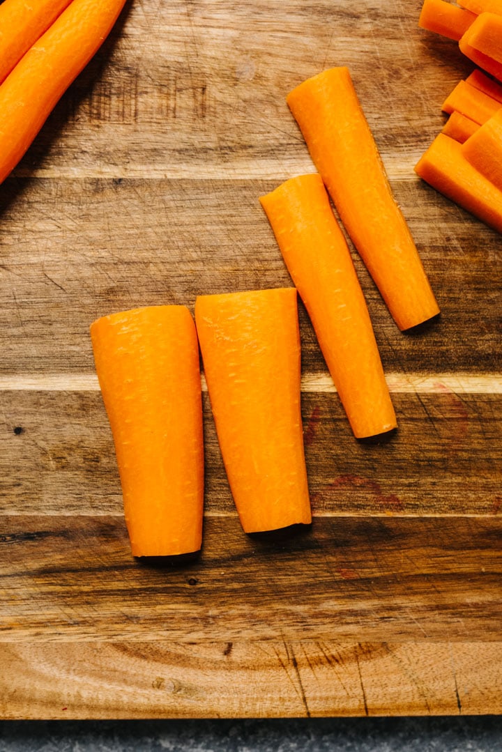 Carrot sticks on a wood cutting board.