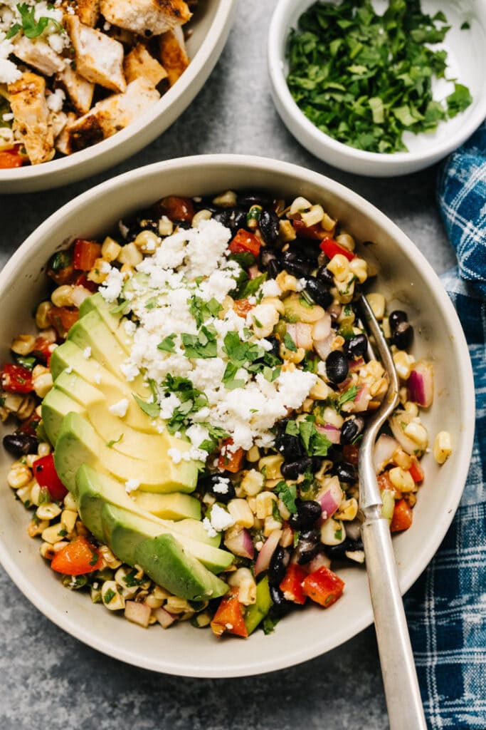 Mexican Street Corn Salad with black beans and avocado slices.