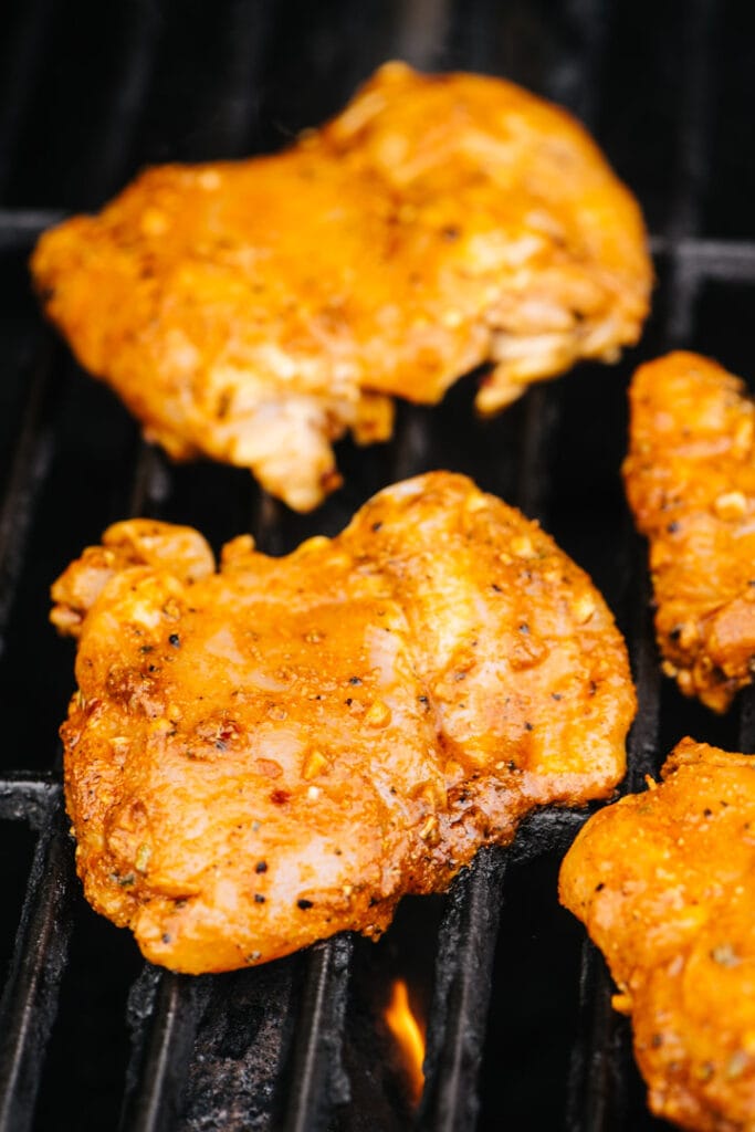 Marinated taco chicken cooking on a grill.