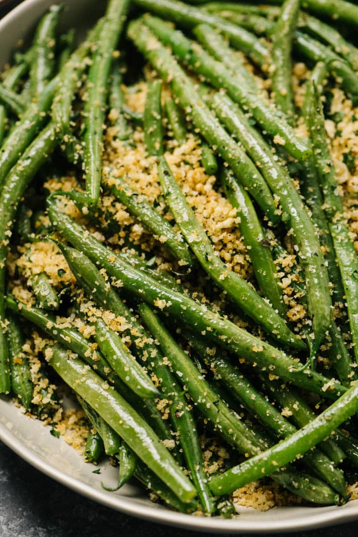 Italian style green beans in a low tan serving bowl.