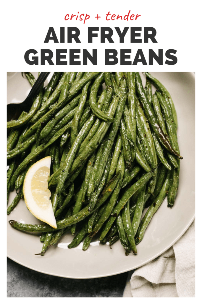Air fried green beans on a plate with lemon and a top banner that read crisp and tender air fryer green beans.