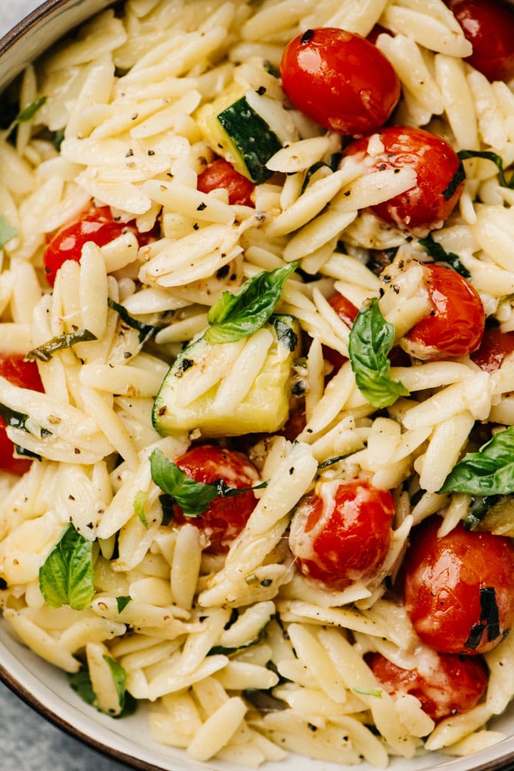 Detail shot of a creamy parmesan orzo recipe with sautéed vegetables.