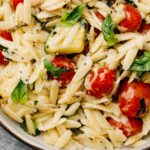 Orzo pasta with tomatoes and zucchini.