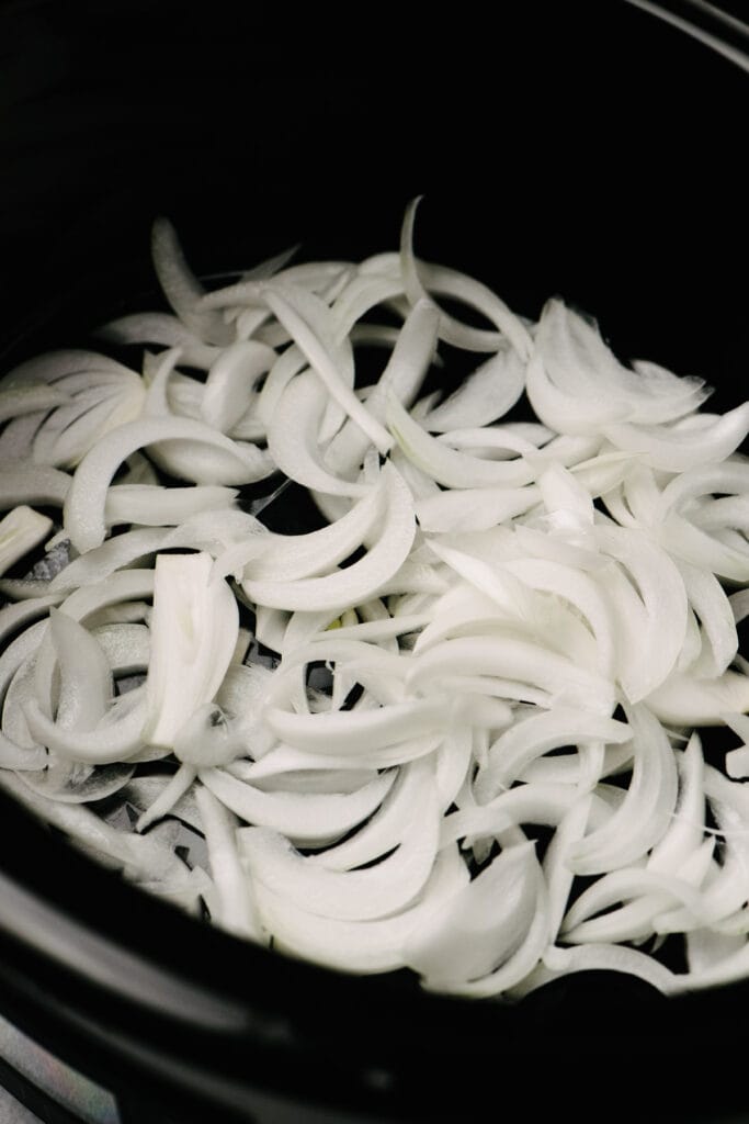 Sliced onions in a crockpot. 