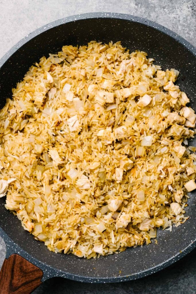 Leftover turkey tossed with rice and soy sauce in a skillet.