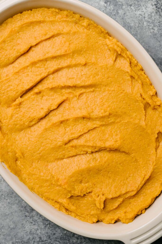 Mashed sweet potatoes in a baking dish smoothed. 