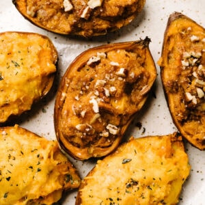 Several halves of twice baked sweet potatoes made sweet and savory, with pecans or cheese as toppings.