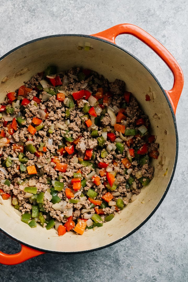 Ground beef sautéed with onion, celery, and bell peppers in a dutch oven.