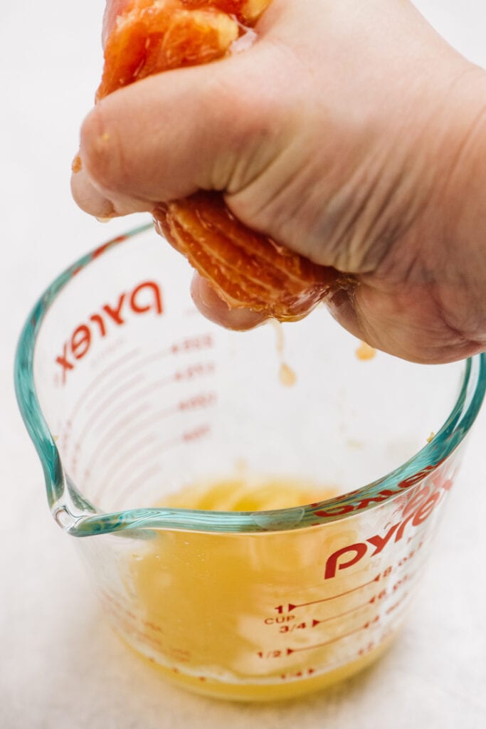 Squeeze the juice from an orange into a pyrex mixing cup.