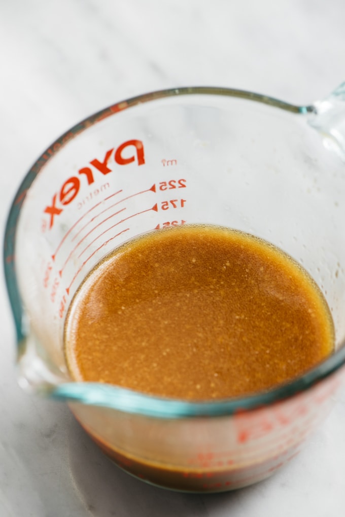 Side view, stir fry sauce in a 1-cup measuring cup.