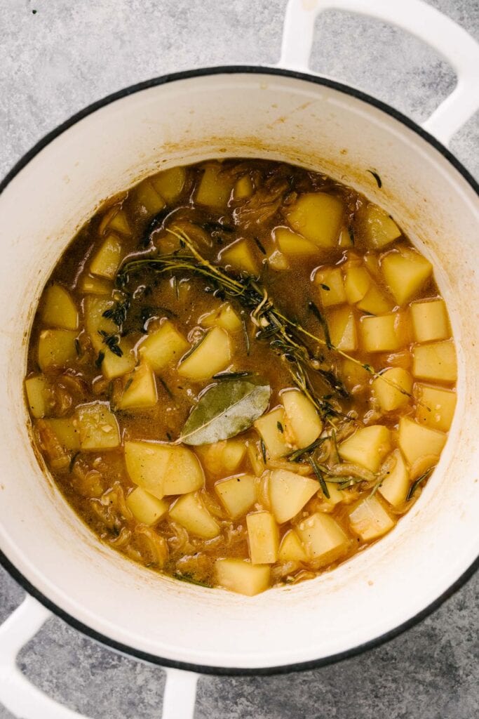 Diced yukon gold potatoes and caramelized onions simmered in broth with fresh herbs in a dutch oven.