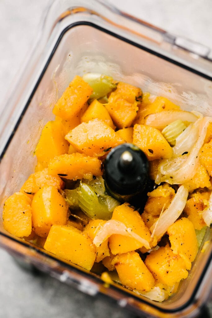 Roasted butternut squash, onions, and celery transfer to a blender.