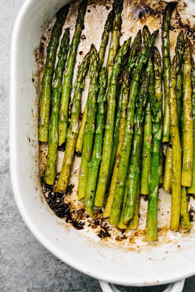 Close up image of baked asparagus with balsamic vinegar in a casserole dish, fresh from the oven.