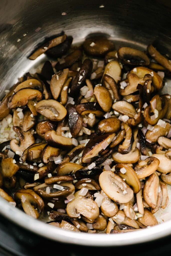 Side view, sautéed mushrooms with garlic and shallots in an Instant Pot.