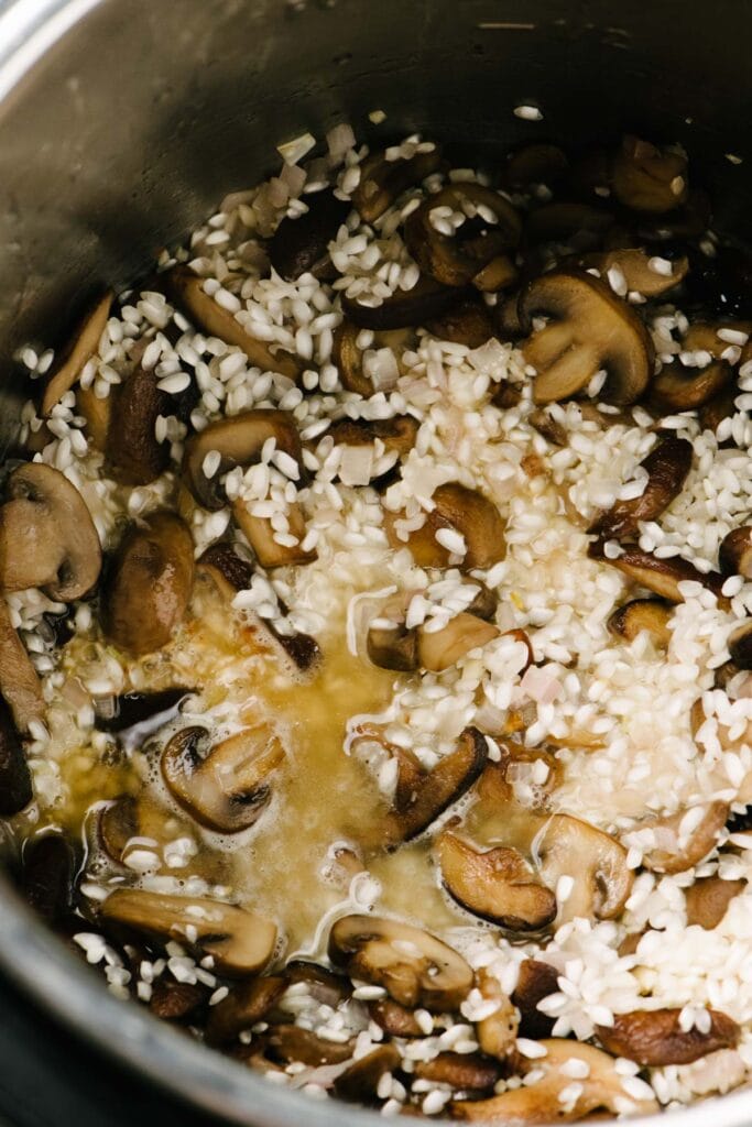 Wine poured into an Instant Pot with arborio rice and sautéed mushrooms to deglaze the pot and clean the bottom for pressure cooking.