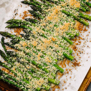 Roasted garlic parmesan asparagus on a parchment lined baking sheet.