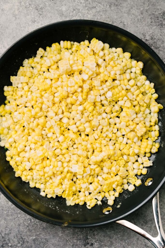 Fresh corn kernels in a skillet tossed with butter and olive oil.