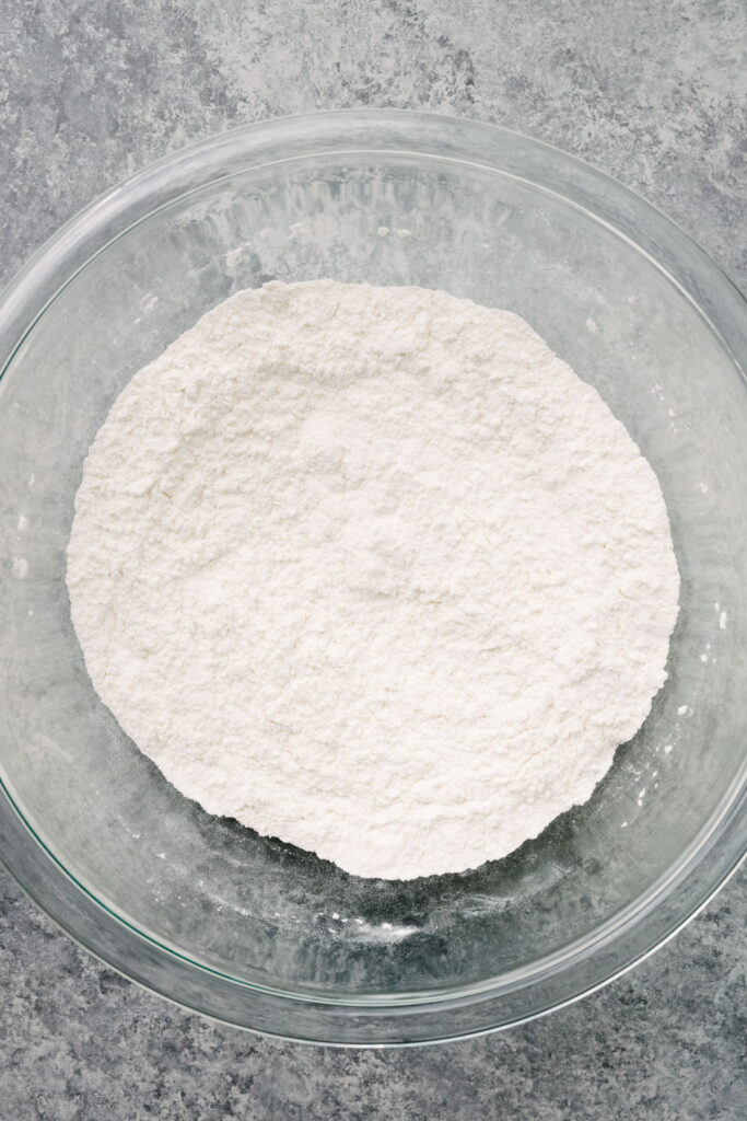 Flour, baking powder, salt, and sugar whisked until well combined in a large glass mixing bowl.