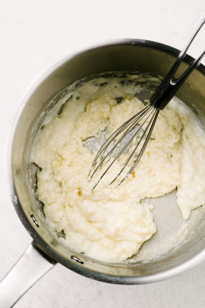 Flour whisked into melted butter in a stainless steel sauce pot.